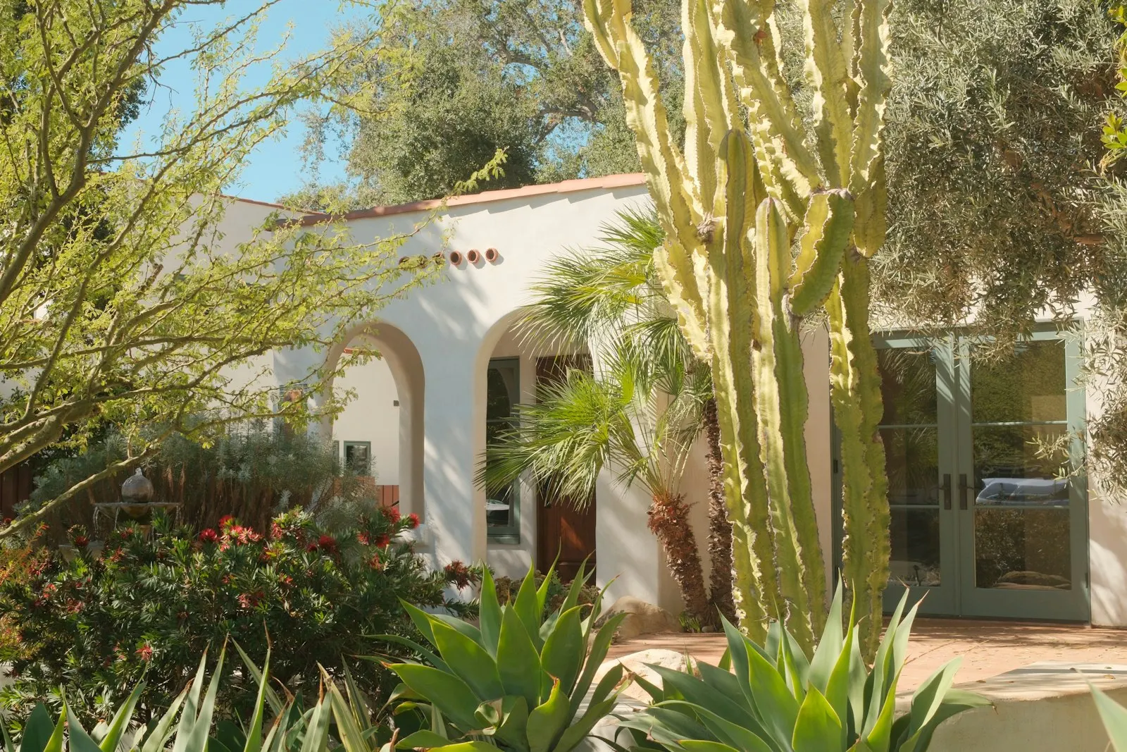 Stucco home with xeriscape front yard — agave, yucca, and decomposed-granite path.